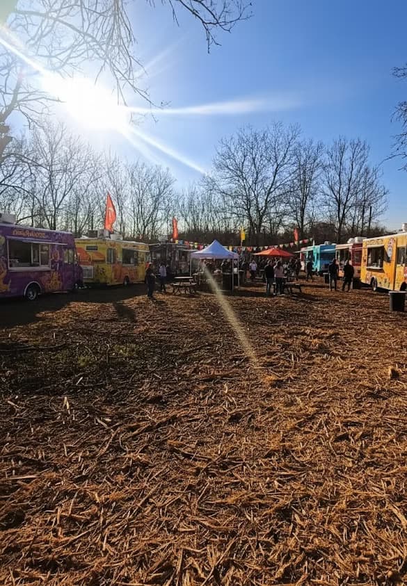Food trucks and vendors at Mines Market in warm golden-hour light.